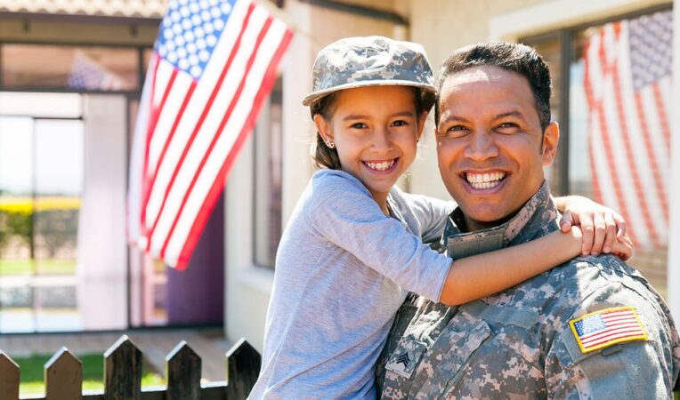 Veteran in uniform holding daughter